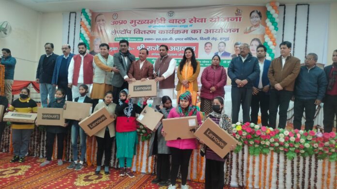 Distributing laptops under Mukhyamantri Bal Seva Yojana