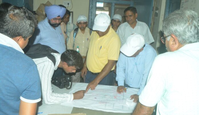 Railway officials looking at the map at Hapur railway station
